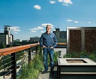 Fargo native son Doug Burgum stands on his rooftop deck. Landscape architect Brian Reinarts outfitted the space with local grasses and plants, LED-illuminated privacy screens, and a natural-gas fireplace.<br><br>Photo by: David Bowman