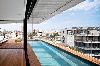 Modern High-Rise Town House in Tel Aviv - Photo 7 of 7 - The decking on the rooftop is Burmese teak and the colorful Picot pouffes are by Paola Lenti.