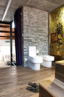 Modern Lilong House Renovation in Shanghai - Photo 9 of 11 - A yellow glass panel divides the shower from the toilet and the bidet.