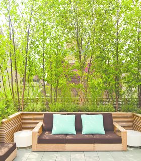 Nelson Byrd Woltz Harnesses the Natural Elements - Photo 5 of 5 - A sofa from Sutherland’s Poolside collection is covered in fabric from Perennials; the illuminated side tables are by Porcuatro for Tango Lighting. The screens are constructed from FSC-certified teak.