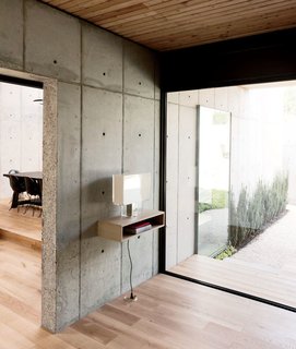 A Texas Couple Builds Their Cast-In-Place Concrete Dream Home - Photo 7 of 17 - In the entryway, a Tati lamp by Ferruccio Laviani for Kartell sits on a shelf Christopher made from kitchen cabinetry scraps.