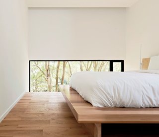 A Texas Couple Builds Their Cast-In-Place Concrete Dream Home - Photo 12 of 17 - The low windows in the master bedroom focus the view on the backyard, not the neighbors. Christopher designed the solid poplar platform bed.