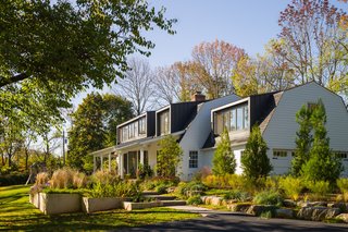 The original Colonial-style exterior included a few small dormers that weren’t large enough to maximize views or welcome natural light into the home. To fix this, Michael installed a series of new ones. Made of standing seam aluminum, they're designed to evoke the feel of local barn windows with a slightly modern twist.