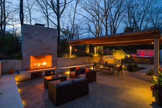 A small wooden deck originally anchored the backyard, which has since been transformed into a larger social area. "We wanted something that was sunken into the earth that would feel like you’re enveloped by the surroundings," Michael says. In order to achieve this, he installed a concrete retaining wall that's level with the soil above it, so foliage will gradually grow into the living space. This feature creates an almost ruin-like feeling and a direct connection to the surrounding landscaping.
