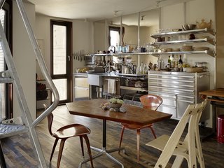 A Cherner Chair Retrospective - Photo 13 of 23 - Outfitted with shelves by EZ Shelving and a generic tool chest, the kitchen’s galvanized steel integrated counter and sink was designed by Baker and fabricated by DeFauw Design + Fabrication. A vintage pair of Norman Cherner’s Plycraft chairs and an A Chair by sustainable furniture-maker David Colwell surround a table by Pacassa Studios, which mounted a custom top on a Herman Miller Eames base. All appliances are electric, including heat-radiating panels, a combo washer-dryer unit, and an induction stove.