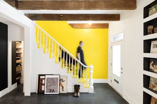 An Old Row House in Montreal Gets a Colorful Modern Upgrade - Photo 1 of 10 - Light from a new skylight pours into the home's entryway and living room. Steel columns and beams were added for structural reinforcement, and the couple left all beams, old and new, exposed.