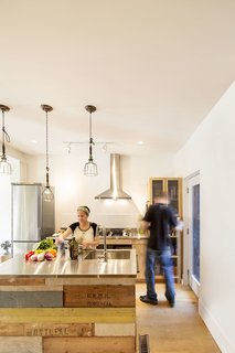 An Old Row House in Montreal Gets a Colorful Modern Upgrade - Photo 6 of 10 - Stainless steel was selected for the kitchen countertops, and the pair relied on a local industrial sheet metal fabricator to help them prepare the material for residential application. The mix of warm and cool adds depth and dimension to the space.
