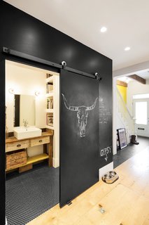An Old Row House in Montreal Gets a Colorful Modern Upgrade - Photo 7 of 10 - The chalkboard wall also acts as a sliding pocket door to the first floor bathroom. To maximize usable space, there are no hinged doors in the home's interior.