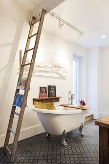An Old Row House in Montreal Gets a Colorful Modern Upgrade - Photo 10 of 10 - A new clawfoot tub sits next to an old wooden ladder that serves as a towel and magazine rack.