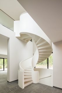 10 Dazzling Modern Staircases - Photo 1 of 10 - A sculptural white steel spiral staircase with wooden treads connects a lower level to an upper cantilevered level in this home near Potsdam, Germany, that was designed by Nps Tchoban Voss. The slim profile of the steel contrasts with the undulating curves of the powder-coated steel railing.