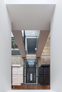 Looking downwards from the second floor, the void creates an invisible barrier between the family room and the living area. The reflection from the skylight exaggerates the idea of an even more depth within the house.