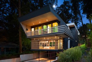 An Angular Futuristic House in Georgia - Photo 1 of 7 - The house was shaped by spatial restrictions. 'The angled walls push the interior spaces outward both visually and as experienced,' says Svenson. 'The horizontal lines of the railings and screen porches add to that. To increase this perception the angled walls occur only in areas suspended in the air—they are never tied to the ground.<br>The architect carved out a parking and storage area underneath the residence. 'The house feels as though it floats above the ground plane,' he says.