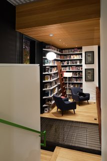 An Angular Futuristic House in Georgia - Photo 4 of 7 - Due to zoning restrictions, the house's footprint had to be relatively small, so Svensen devised a solution: split levels. The library occupies a landing on the staircase and features shelves built by Atlanta's Dark Horse Woodwork.