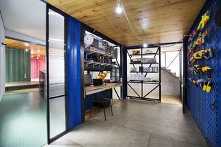 How to Stay Cool by Living in a Shipping Container - Photo 6 of 10 - The hobby room features a custom desk and shelving system that Atelier Riri designed and manufactured themselves. A custom frame holds the family’s tools and other objects on the eastern wall.