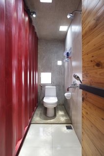 How to Stay Cool by Living in a Shipping Container - Photo 8 of 10 - In one of the home’s three bathrooms, a TOTO toilet is illuminated by LED light fixtures from OSRAM. Simple square-shaped skylights and windows allow natural light to fill the space.