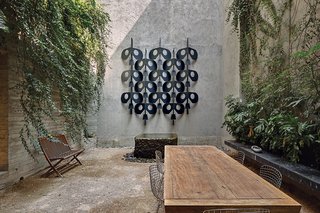 A Sublime Indoor/Outdoor Retreat in Mexico City - Photo 3 of 5 - The house features several courtyards, conveying an ever-present sense of indoor-outdoor living. Concrete walls are lined with yellow jasmine, and the wall sculpture is taken from Manuel Felguérez’s fence for the National Anthropology Museum.