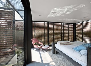 45 Pets in Beautiful Modern Homes - Photo 39 of 45 - The master bedroom is shaded by exterior slats in cumaru, a sustainable tropical wood. Alazraki designed the custom bed frame.