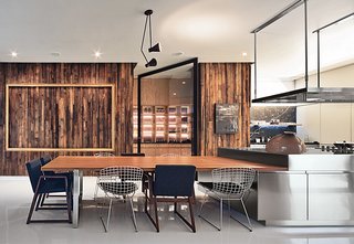 A Sublime Indoor/Outdoor Retreat in Mexico City - Photo 5 of 5 - A vintage Lightolier pendant and sleek Arclinea cabinets by Antonio Citterio stand out against a wall paneled in reclaimed pine in the kitchen. Seating is a mix of Bertoia wire chairs and armchairs by the Mexican designer Hector Esrawe.