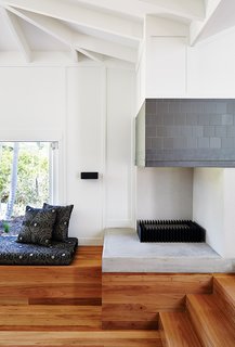 This Kitchen Brings It All Together - Photo 4 of 4 - In the living area, an EcoSmart Fire ethanol-fueled fireplace is lined in charcoal tile by Winckelmans; the bench cushion is upholstered in Gillespie Onyx from Warwick Fabrics.