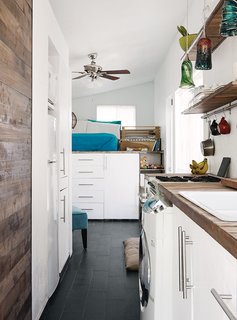 Porcelain floor tile from Daltile is a durable, easy-to-clean substitute for wood. The family does laundry in an efficient Summit SPWD1800 washer-dryer combination unit. Miller saved money in the kitchen by using a reclaimed sink and faucet and drawer pulls from Ikea.