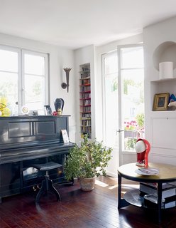 10 Dreamy Parisian Homes - Photo 4 of 10 - The metal-topped side table is from Roche’s grandparents’ house and the lamp is vintage Vico Magistretti for Artemide.
