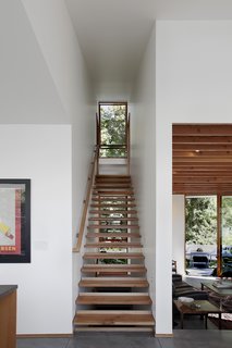 8 Beautiful Home Projects Using Reclaimed Wood - Photo 2 of 8 - A small, efficient home in Seattle designed by SHED Architecture & Design incorporated wood on the exterior and interior of the home, and even used salvaged wood from the residence that had previously stood on the site. Although the 100-year-old bungalow was demolished, the treads of one of its staircases were repurposed in the new home as a modern, open-riser stair that lets in light from the windows beyond.