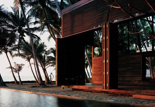 It’s hard to believe that this idyllic house sited in a coastal coconut grove in Nandgaon, India, is a mere hour’s drive from bustling Mumbai. For architect Bijoy Jain, principal at Studio Mumbai Architects, making the most of the muggy locale meant foregoing walls for louvers and slatted sliding doors—and opting for local materials to construct the airy home. "Response to weathering is critical along the seaside," he explains. The East Indian laurel, Burma teak, and palmyra woods will endure the seaside climate with an oiling after each monsoon. The pool that runs between the two structures of the home contrasts the choppy white-capped ocean with tranquil charm, making it a favorite spot for the vacationing family of four, who spend weekends here at the retreat.