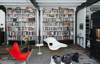 In the living area of Daniel Rozensztroch’s Paris apartment, an Eames La Chaise and a butterfly chair complement a Moroccan Berber rug.