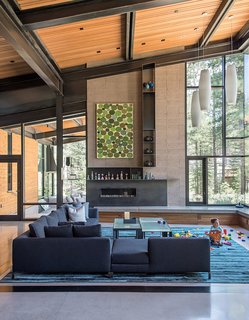 A Forest Sanctuary Designed to Support Autistic Triplets, Their Parents, and a Host of Caregivers - Photo 1 of 19 - A piece by John Belingheri hangs in the living room of the Bancroft family’s home, which is centered by an Antonio Citterio sofa and Robert Marinelli tables.