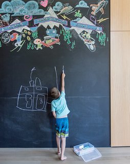 A Forest Sanctuary Designed to Support Autistic Triplets, Their Parents, and a Host of Caregivers - Photo 5 of 19 - The library holds a wall-size blackboard for the Bancrofts’ four children, with a colorful permanent piece by local artist Derek Phillips.