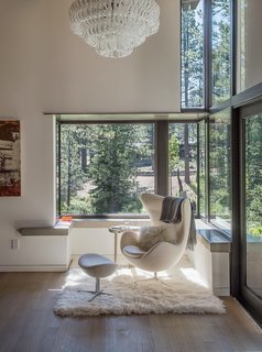 A Forest Sanctuary Designed to Support Autistic Triplets, Their Parents, and a Host of Caregivers - Photo 9 of 19 - In one corner of the room, an Arne Jacobsen Egg chair and ottoman rest on a flokati rug. Overhead is an Ecos pendant by Vistosi.