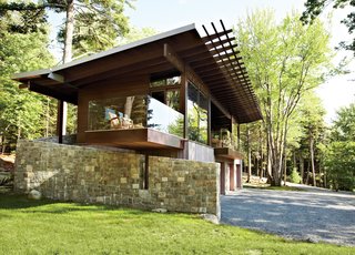 Frank Lloyd Wright-Inspired Style and Camping Collide in Maine - Photo 1 of 5 - From its locally quarried stone foundation to its zinc-coated copper roof, the cottage was inspired by its surroundings. "We talked a lot with our client about what the materiality would be," says architect Karen Stonely, who, citing the organic style of Bar Harbor architect Robert Patterson, designed the structure with wood rather than drywall.