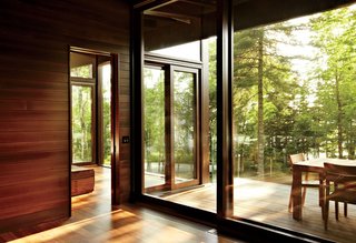 Frank Lloyd Wright-Inspired Style and Camping Collide in Maine - Photo 3 of 5 - Douglas fir-framed windows by Dynamic Architectural Windows & Doors offer layered indoor-outdoor views.