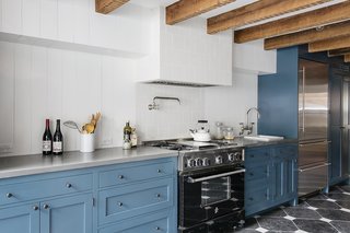 A Neglected Brooklyn Townhouse Becomes a Home That’s Primed for Entertaining - Photo 2 of 8 - "They knew they wanted a big kitchen where all of their friends could stand around and be involved in the cooking process," Roberts said of the owners. Exposed beams stripe a ceiling above Wood Mode cabinets painted Newport Green by Benjamin Moore.