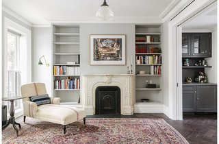 A Neglected Brooklyn Townhouse Becomes a Home That’s Primed for Entertaining - Photo 3 of 8 - As much as the owners and Roberts wanted – and needed – to modernize the home, they also tried to honor some of its historical touches. They preserved the mantel, and replaced the plaster crowns on the parlor level. The antique chaise is by Lisa Sherman, and the walls are painted pavilion gray by Farrow & Ball.