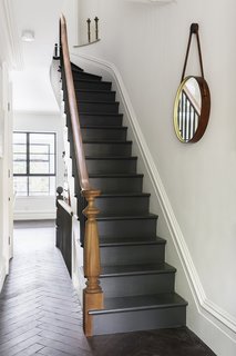 A Neglected Brooklyn Townhouse Becomes a Home That’s Primed for Entertaining - Photo 4 of 8 - Reclaimed oak with a custom finish by LV Wood surrounds a staircase in a herringbone pattern. The new stairs are painted off black by Farrow & Ball, and the handrail that lines them is of salvaged mahogany.