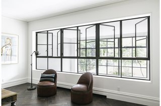 A Neglected Brooklyn Townhouse Becomes a Home That’s Primed for Entertaining - Photo 7 of 8 - "We did a lot of studies for the project to show how we could get huge amounts of light into the rear of the house," Roberts said, which culminates in the two-story addition that replaced the original collapsing wall. The living room’s two antique round leather chairs, by Ralph Lauren, are within view of the garden beyond matching sets of windows.