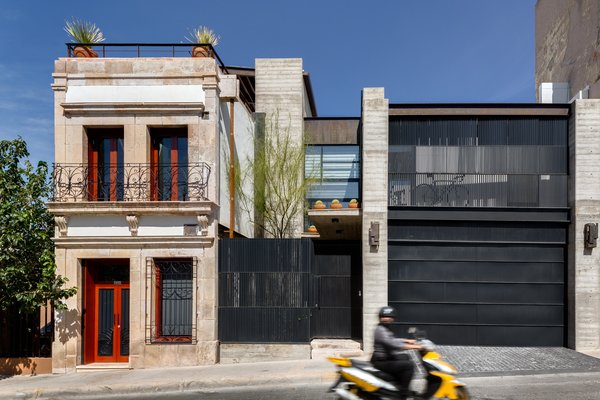 The early-20th-century structure is seen next to the 300 square meter modern addition. A garage and patio were added, as well as a balcony that would complement the proportions of those in the original building. According to Quevedo, the biggest challenge was to approach both structures with a “common language” and explore the idea that “preservation and modernity can coexist.” Photo of Hybrid Home modern home