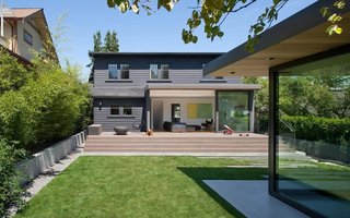 The landscaped backyard acts as a second, open-air living space between the home and garage studio. The cladding on the addition is painted in Benjamin Moore’s Iron Mountain, and the deck is stained western red cedar.