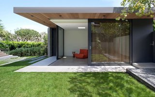 The garage studio shares a space for the owners’ car with a multitude of functions ranging from gym to playroom. It complements the home's addition with shared materials: stained western red cedar and the same Iron Mountain shade by Benjamin Moore.