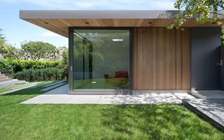 "Before, the house turned its back on the landscape," said Parish. "This renovation and addition really animates the garden." Sliding glass doors match those of the living room beyond the deck, and both can be completely open to the yard.