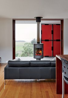 An Off-the-Grid Prefab that Combines Open Plan Living with Rugged Durability - Photo 5 of 10 - The fireplace, by Rais, can rotate in different directions for both indoor and outdoor use.