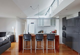 An Off-the-Grid Prefab that Combines Open Plan Living with Rugged Durability - Photo 6 of 10 - Inside, bar stools by Anibou, appliances by Miele, and gray cabinets from IKEA furnish a simple kitchen.