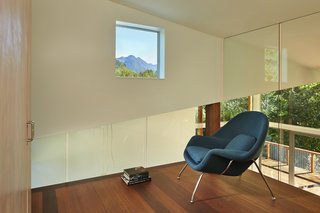 Every room in the home has views to the outdoors, including the loft. Glass walls box in Womb Chairs by Modern Classics.