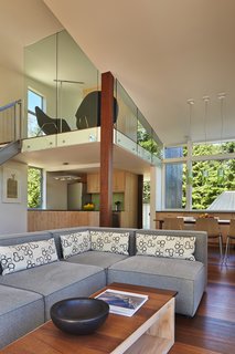 The living room features a "Focus One" couch by Kasala, which sits across from Arper and Catifa 46 dining room chairs by Hive Modern. The pendant lights that hang above them are "Easy" by Kartell.