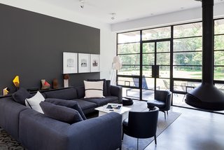 A Couple Takes an Unassuming Plot of Land and Calls it Home - Photo 11 of 11 - Situated near the south-facing facade, the main living space is furnished with a Michel sectional from B&B Italia, Feel Good side chairs by Flexform, and a suspended Ergofocus fireplace from Focus.