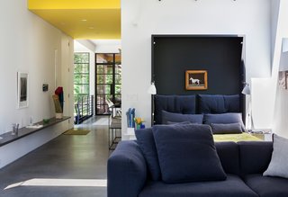 A Couple Takes an Unassuming Plot of Land and Calls it Home - Photo 5 of 11 - When folded down, deep navy-blue cushions give the effect of a lush headboard. While the home does not yet have a proper master bedroom, the couple plans to create an addition sometime next year.