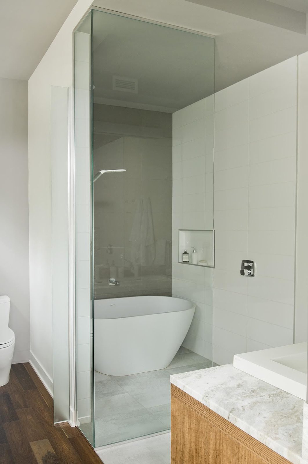 An Emily quartz bathtub by Caml-Tomlin is surrounded by Ceragres’ fade and frammenti tile.