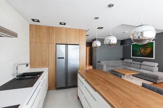 10 Open Kitchen Solutions That Will Get Things Cooking - Photo 6 of 10 - The neutral color palette of this home extends to the kitchen, which is overhung by several pendant globes.