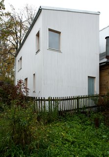 A Compact Home in Moscow Built on the Lowest Possible Budget - Photo 2 of 9 - Placed throughout the home’s slatted wood exterior, windows are positioned to allow for the most attractive views and ample natural light. The sloped roof design was chosen for its minimal cost, and for its ability to redirect snow away from a neighboring residence.